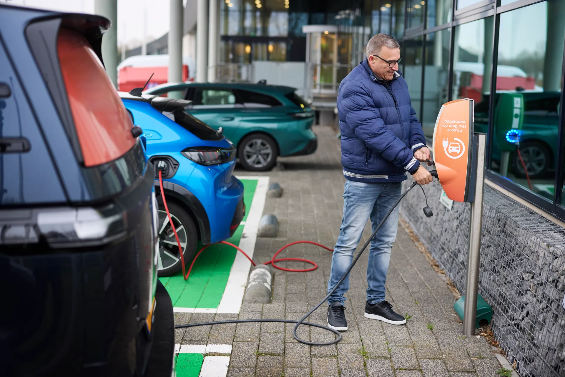 Een logistieke medewerker laadt zijn elektrische busje op.