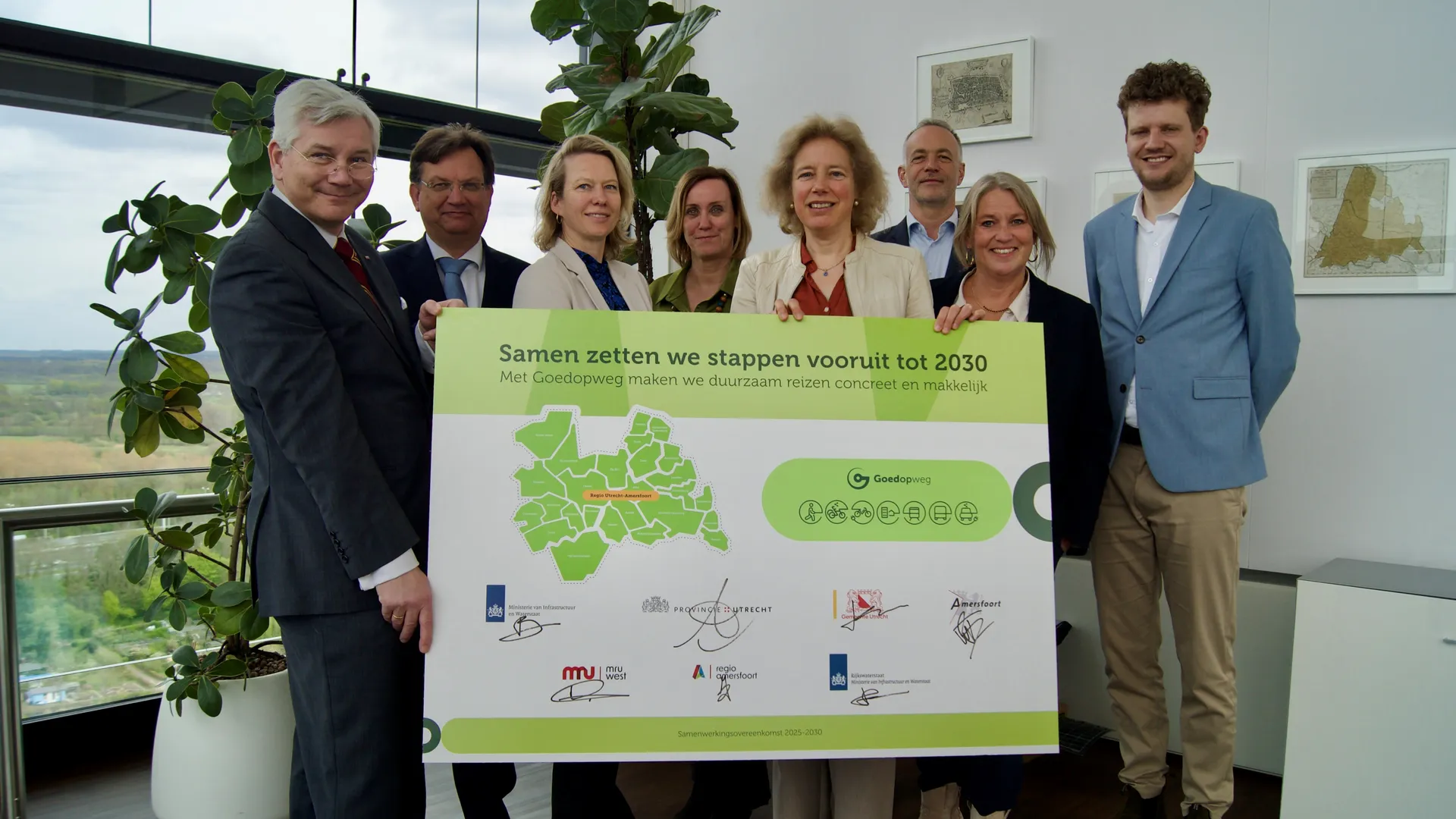 Samen zetten we stappen vooruit tot 2030. Met Goedopweg maken we duurzaam reizen concreet en makkelijk.

Deze beschrijving identificeert een gezamenlijk onderteken- of samenwerkingsmoment georganiseerd door Goedopweg, met een groep volwassenen die een groot groen-wit bord vasthouden.