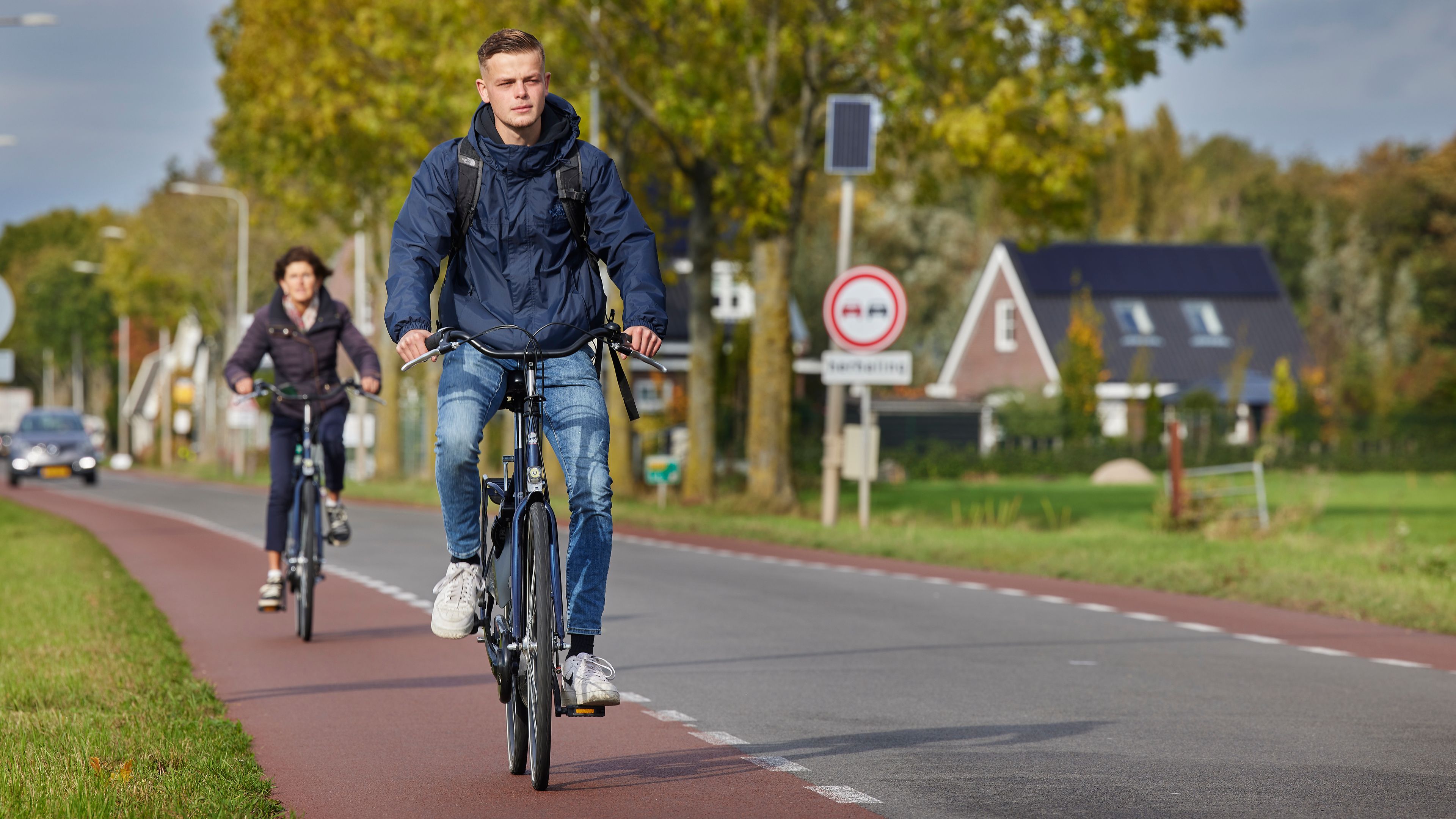 Meerdere fietsers rijden over een fietspad langs de weg