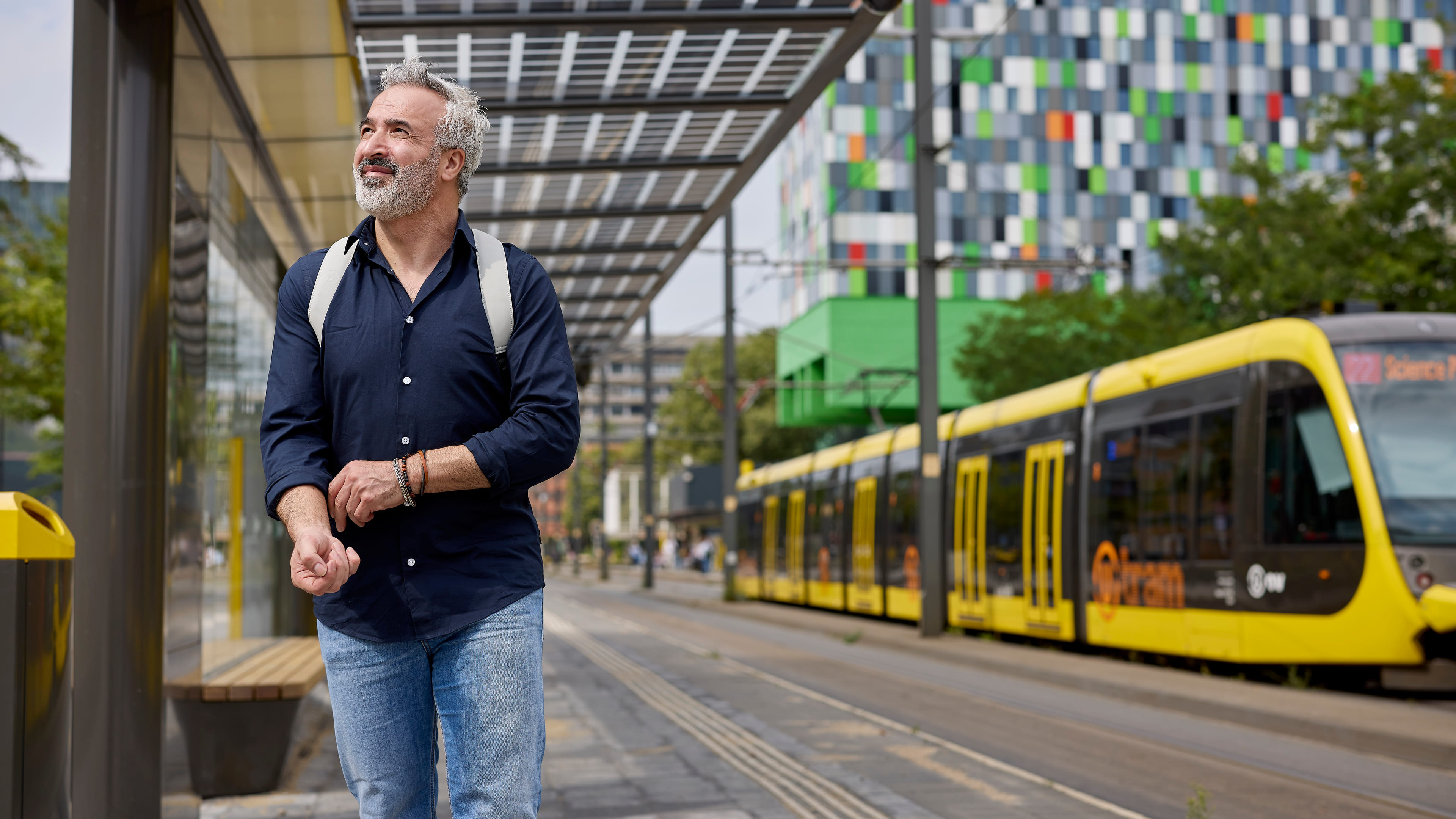 Je ziet een mannelijke medewerker weglopen bij een tramhalte op Utrecht Science Park