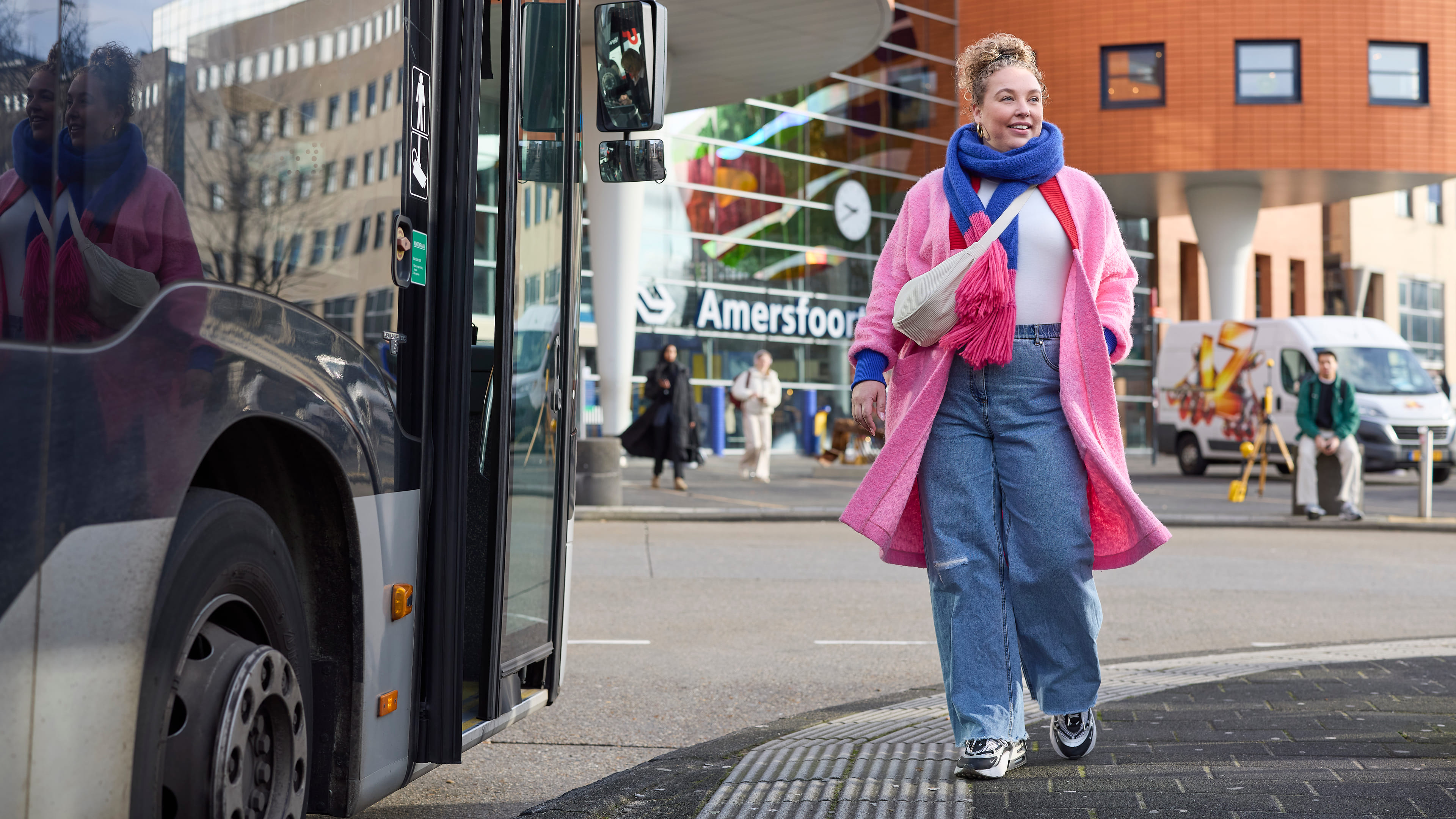 Een mevrouw die naar de bus loopt op Station Amersfoort Centraal