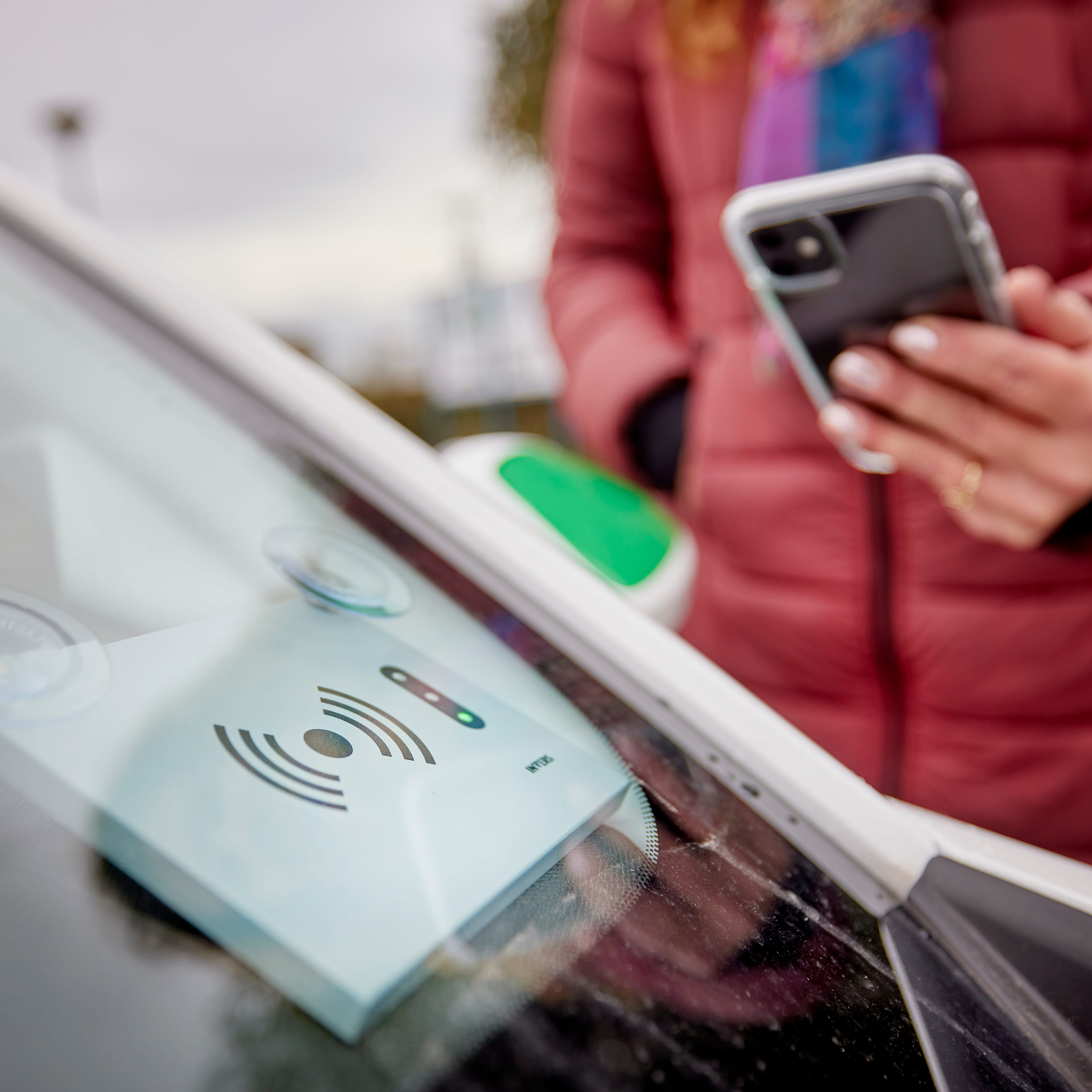 Een vrouw opent een deelauto met een app op haar smartphone.