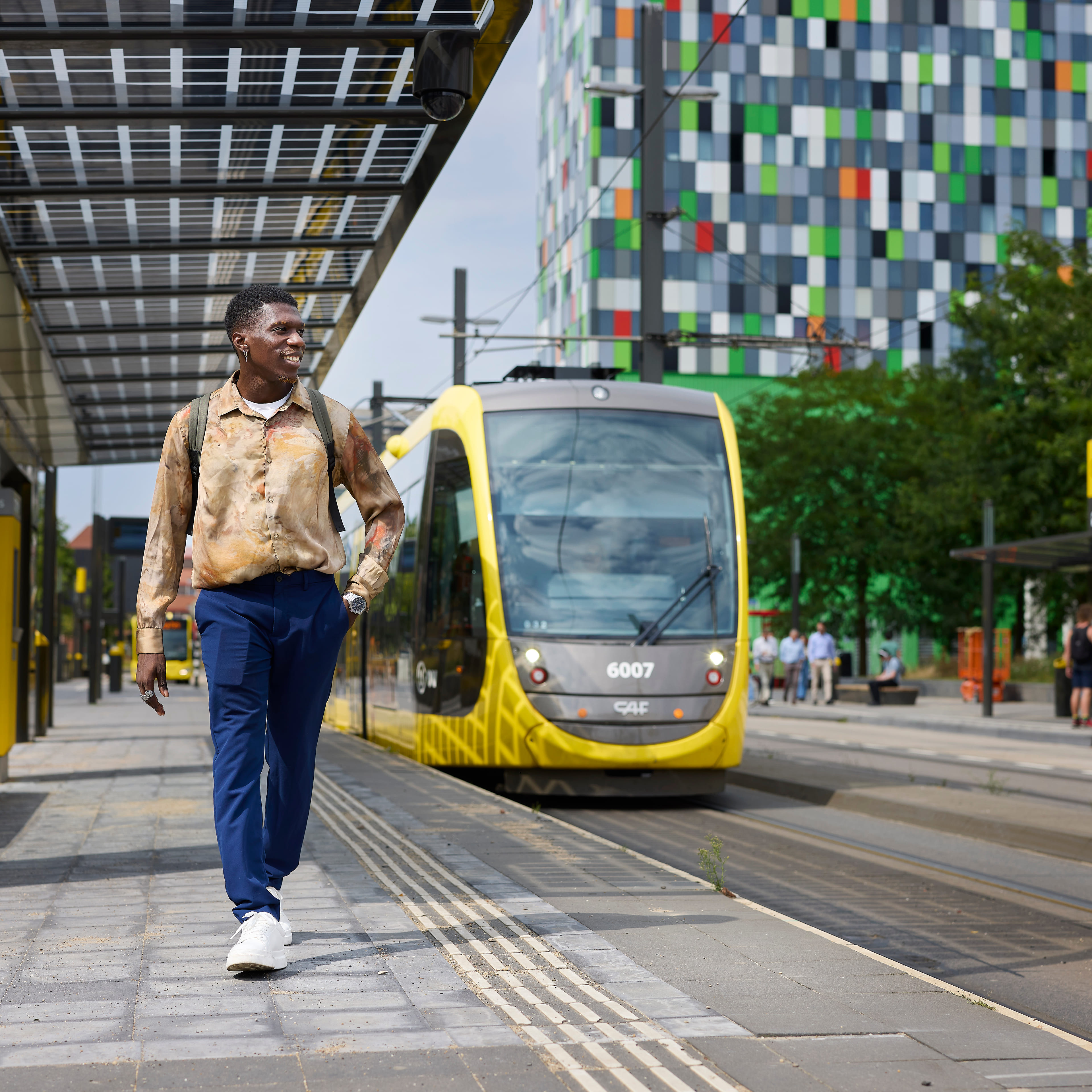 Je ziet een mannelijke student weglopen bij de tramhalte in Utrecht