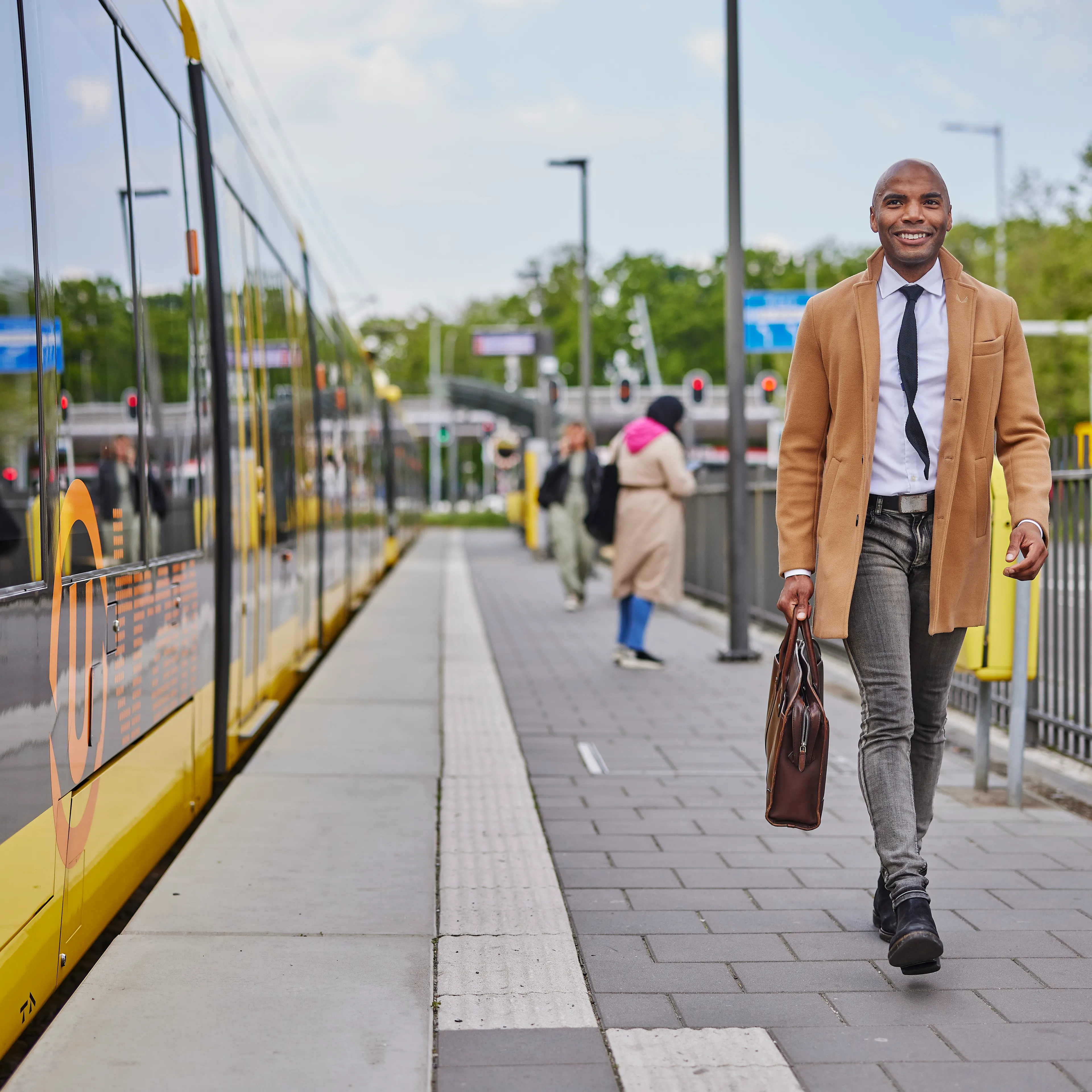 En meneer loopt naast de tram