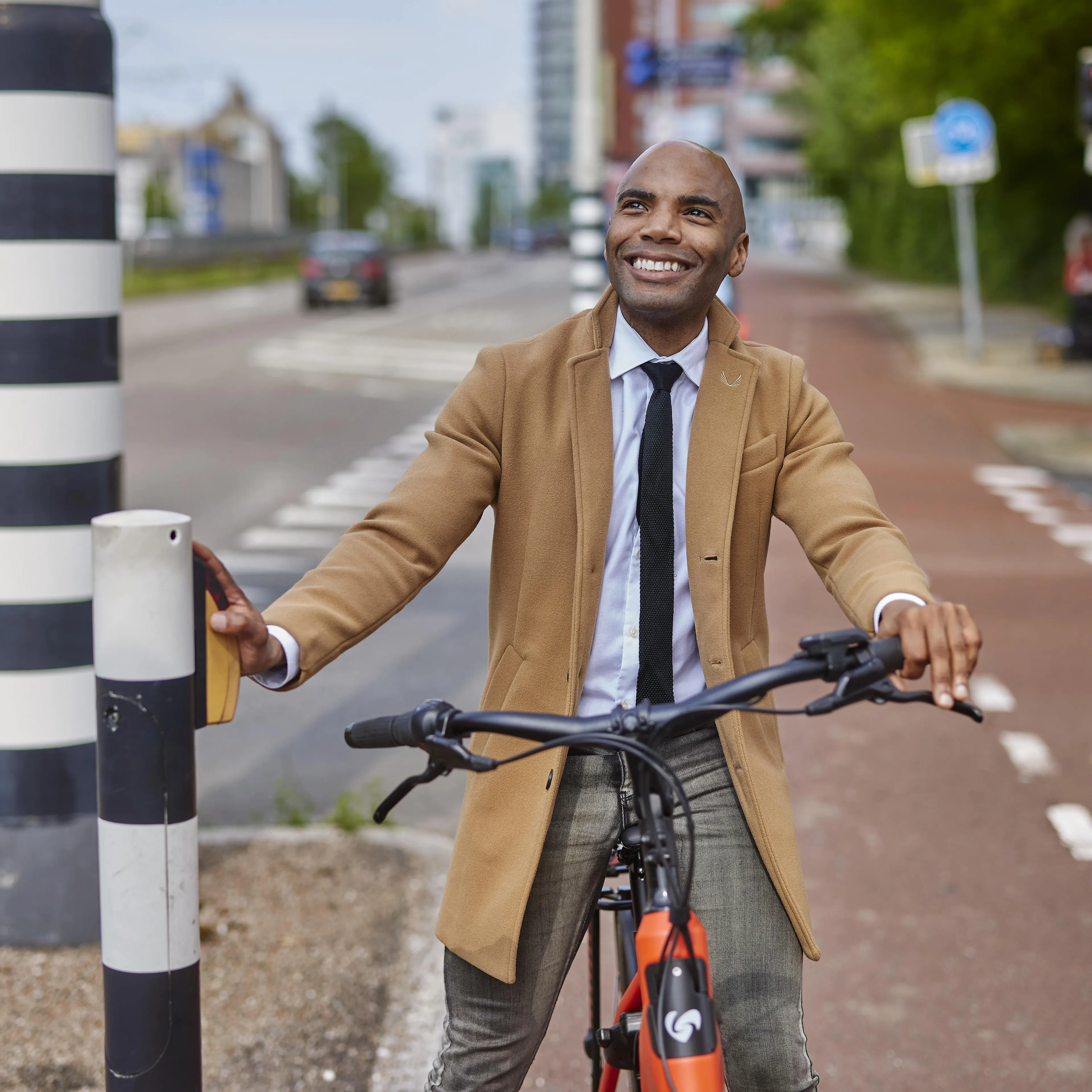 Een man op de fiets staat stil bij het stoplicht