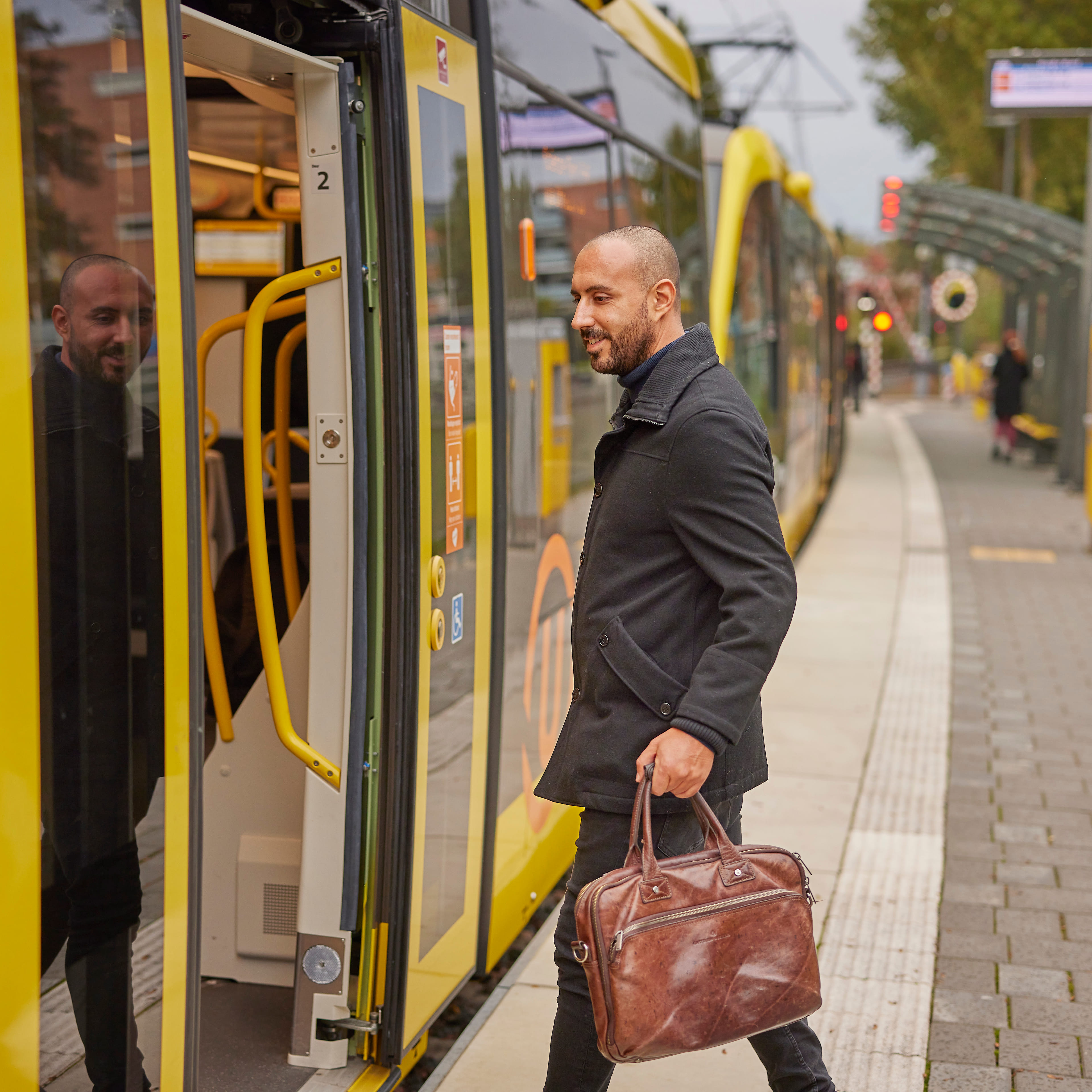 Werknemer stapt in de tram