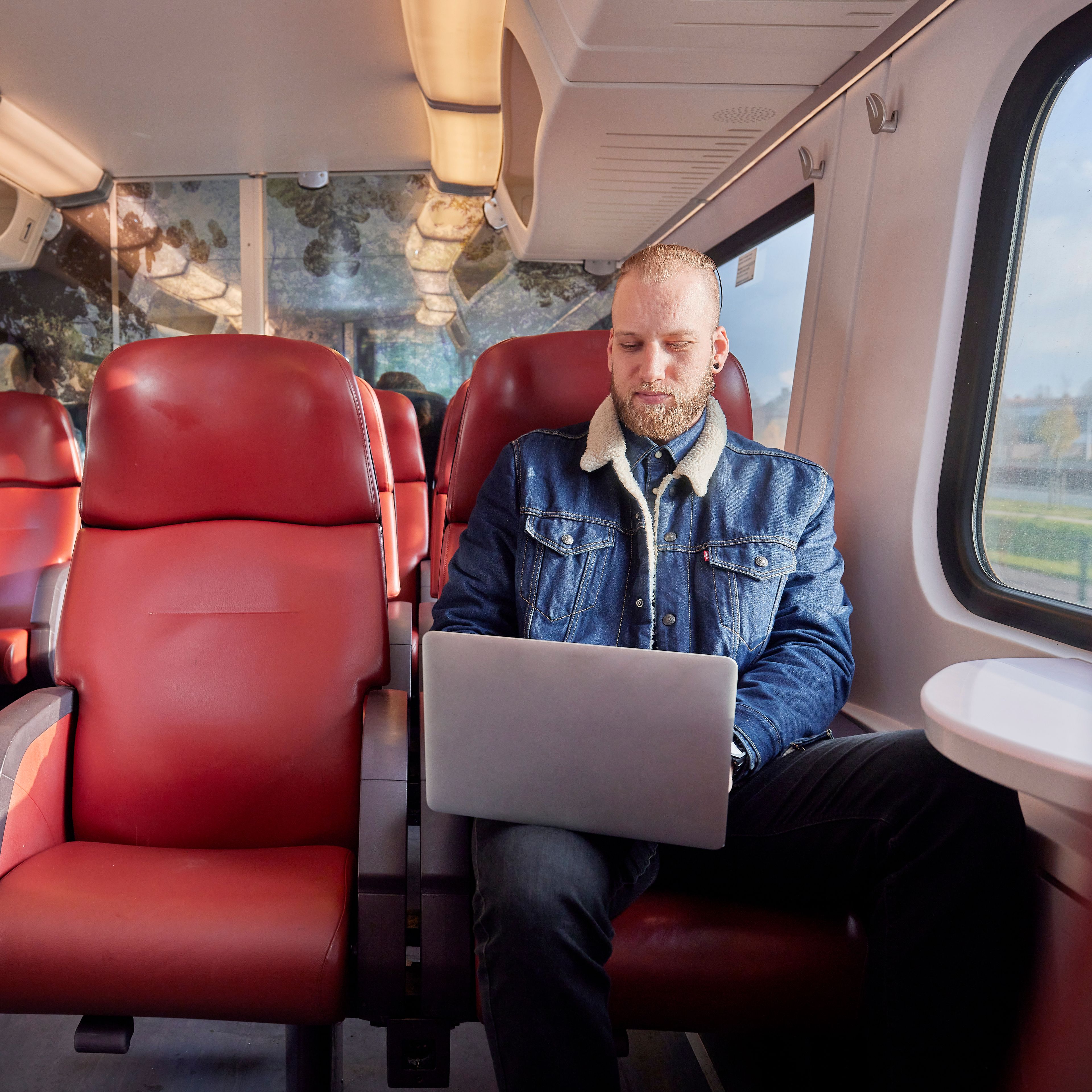 Man is aan het werk op zijn laptop in de trein