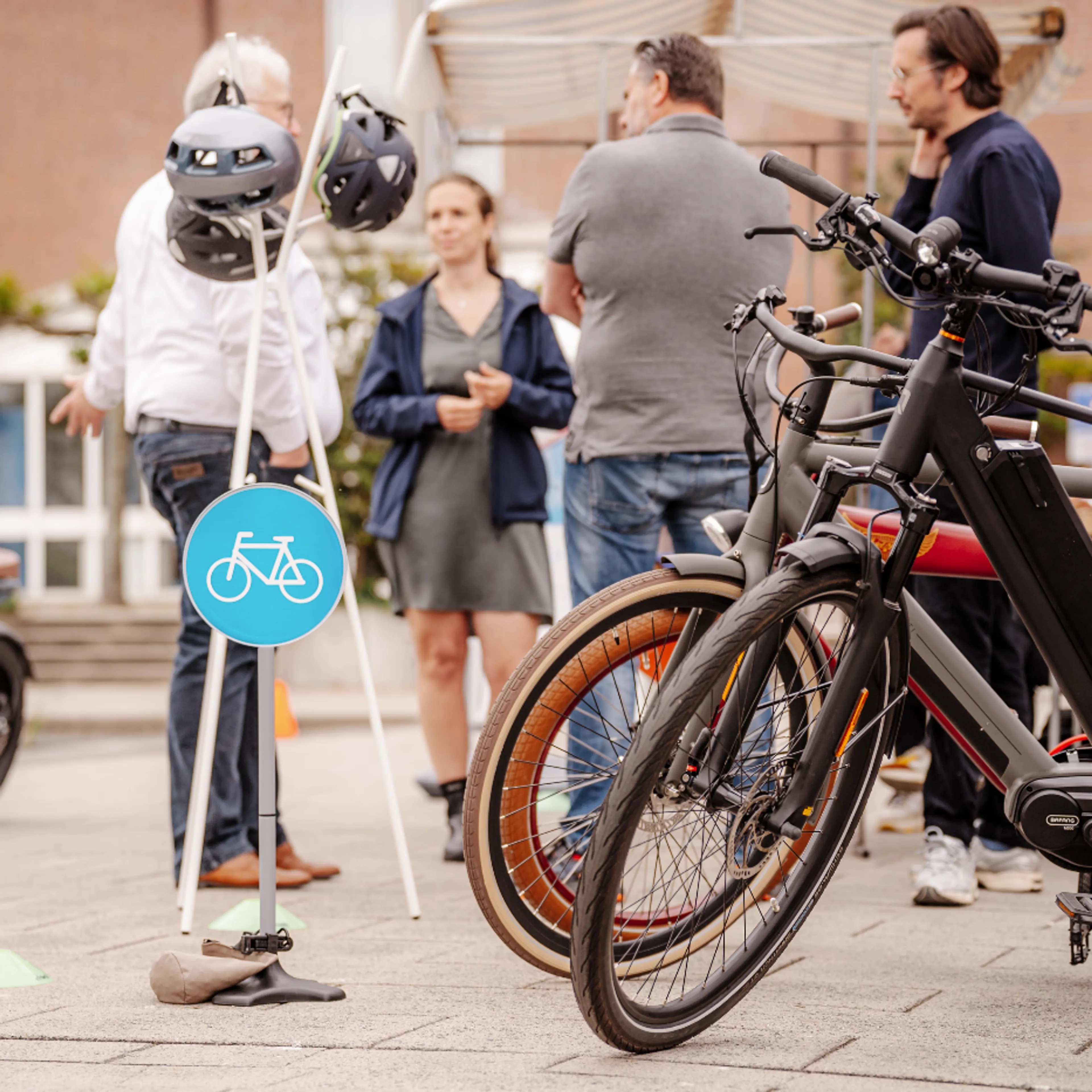Een groep mensen staat bij verschillende soorten e-bikes
