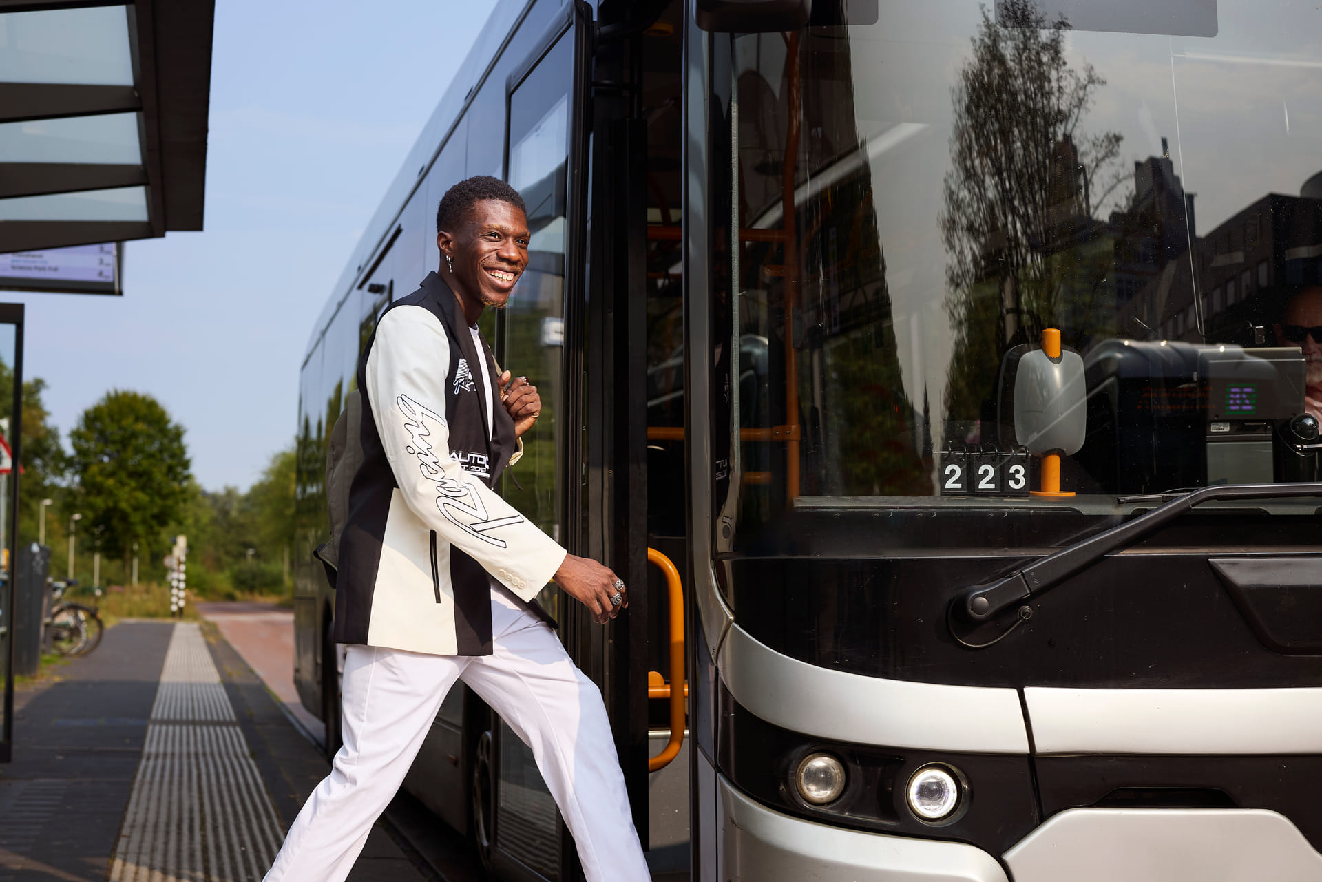 Jonge man stapt in de bus bij een bushalte
