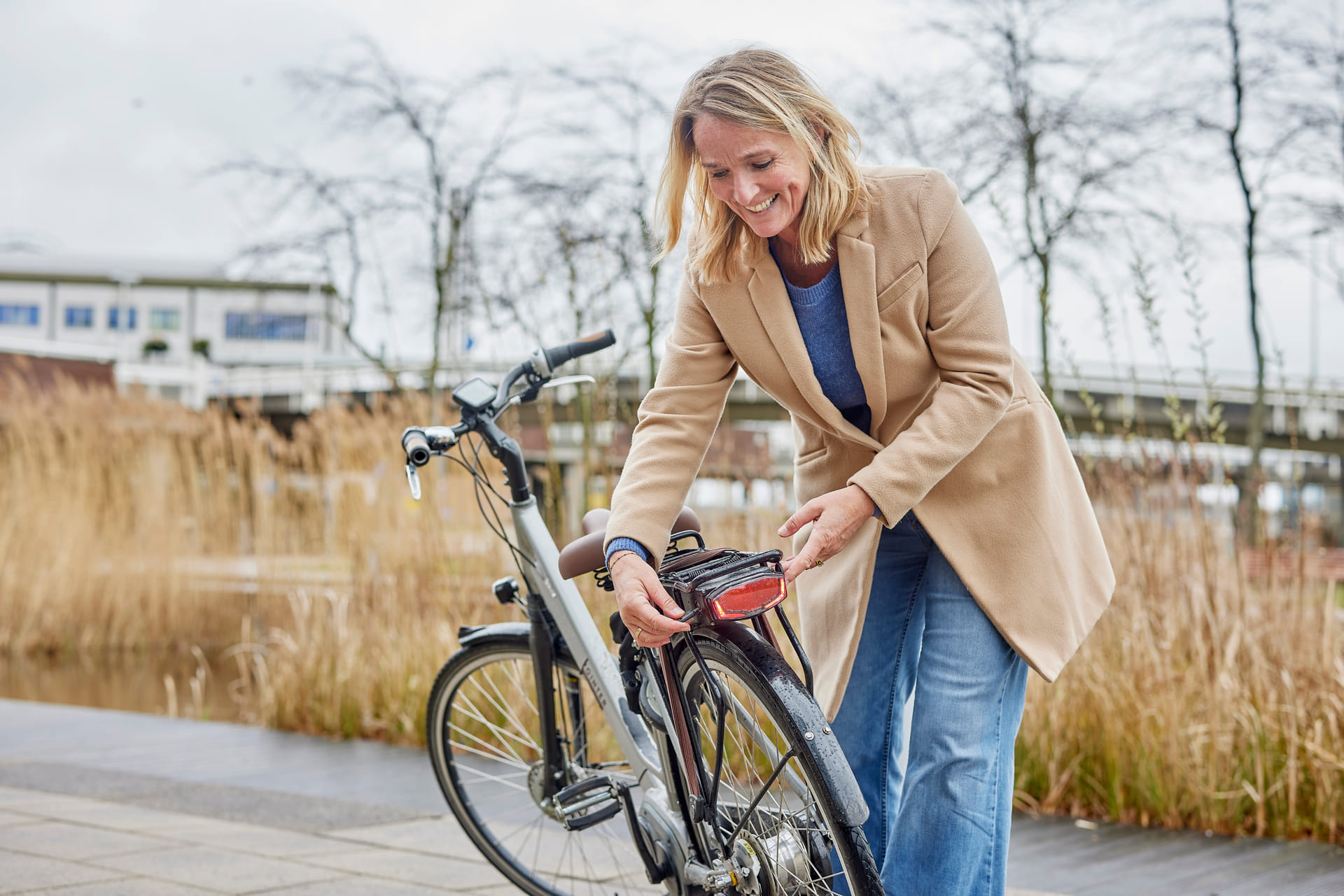 Vrouw is bezig met de accu van haar elektrische fiets