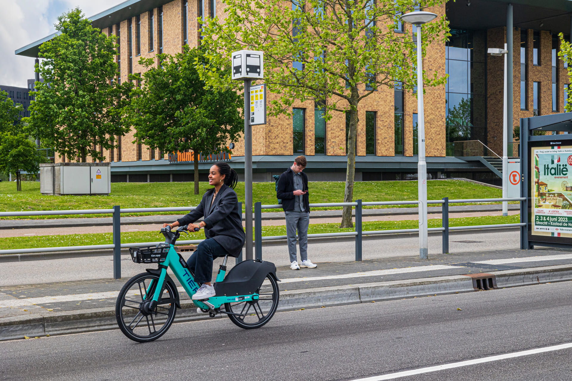 Een mevrouw fiets over bedrijventerrein Papendorp op een elektrische deelfiets.