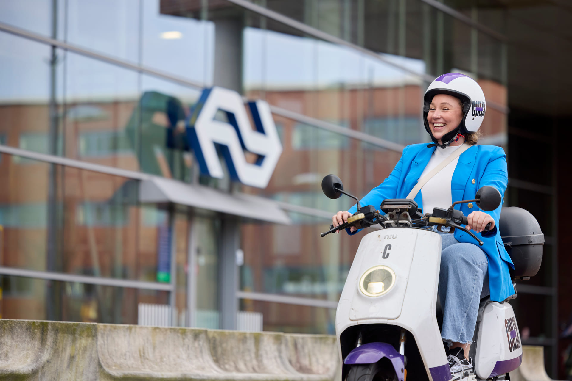 Mevrouw op een check deelscooter rijdt langs Amersfoort Centraal