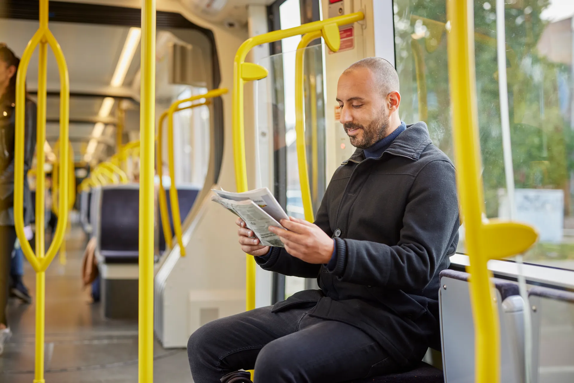 Man leest de krant in de tram