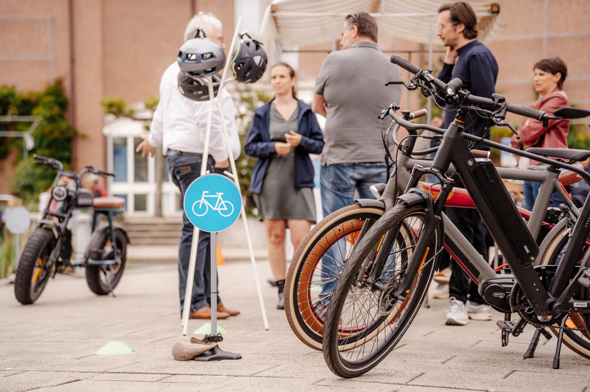 Een groep mensen staat bij verschillende soorten e-bikes