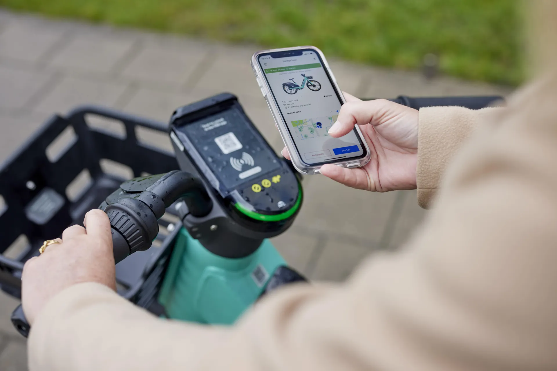 Een mevrouw gebruikt de Dott-app, terwijl ze op haar fiets zit.